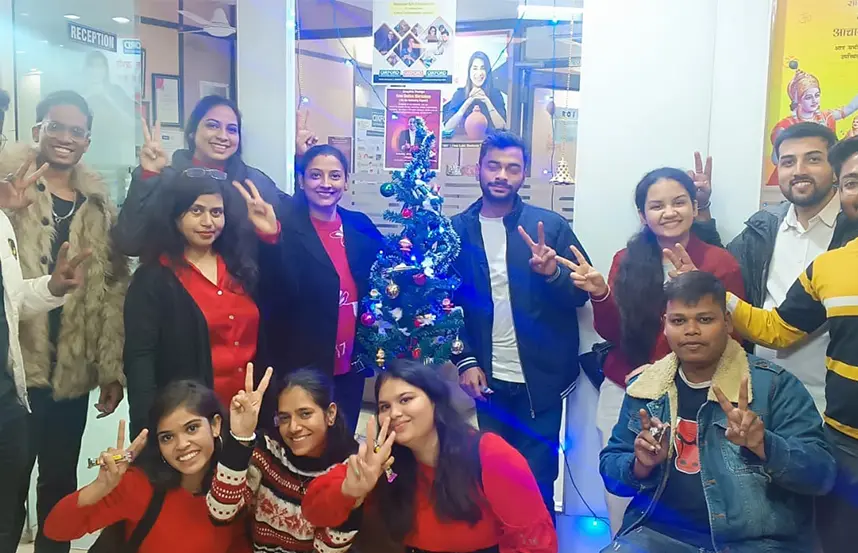 Students and staff celebrating Christmas around a decorated tree at Oxford Software Institute